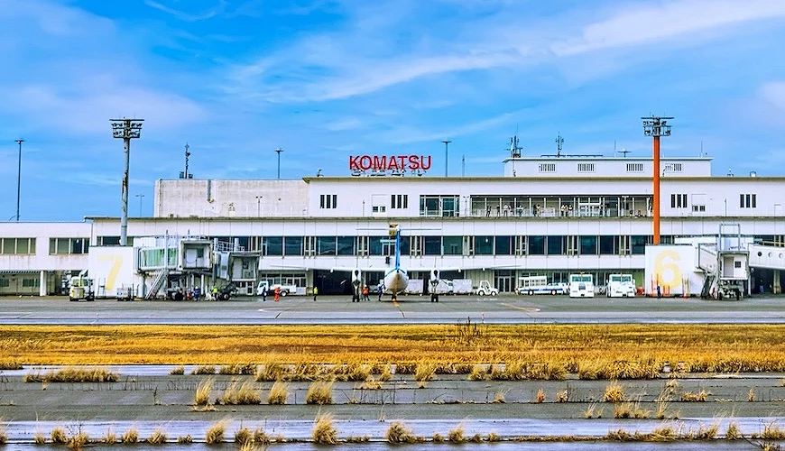 從飛機跑道看向小松機場,白色建築與大大的紅色英文字樣招牌