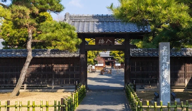 日本最古老學校「足利學校」的入口校門,木造建築前有整齊庭園與松樹
