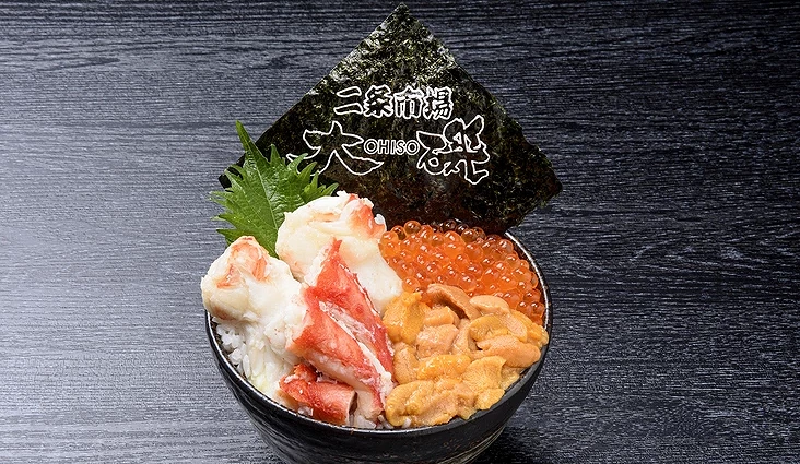 蟹肉、海膽與鮭魚卵盛放在白飯上