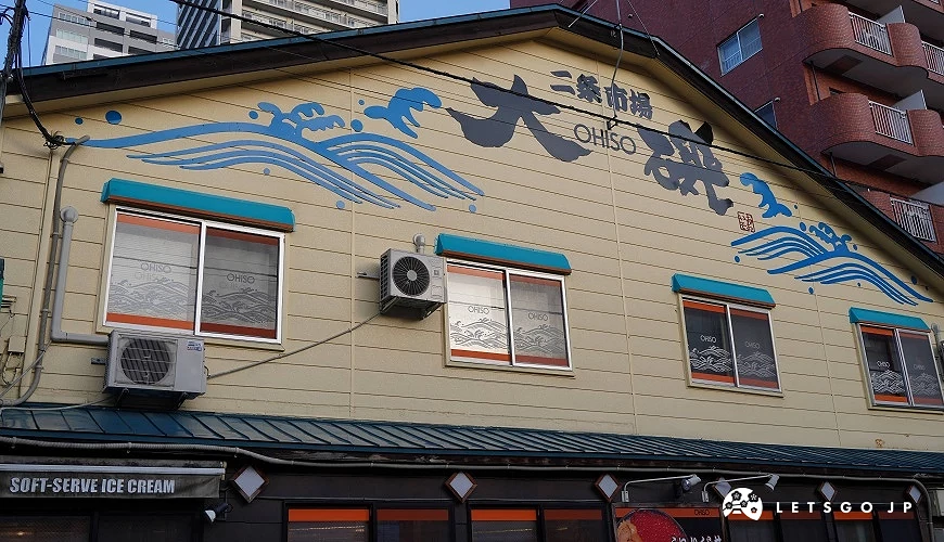 大磯建築外觀,牆面繪有藍色海浪與店名字樣。