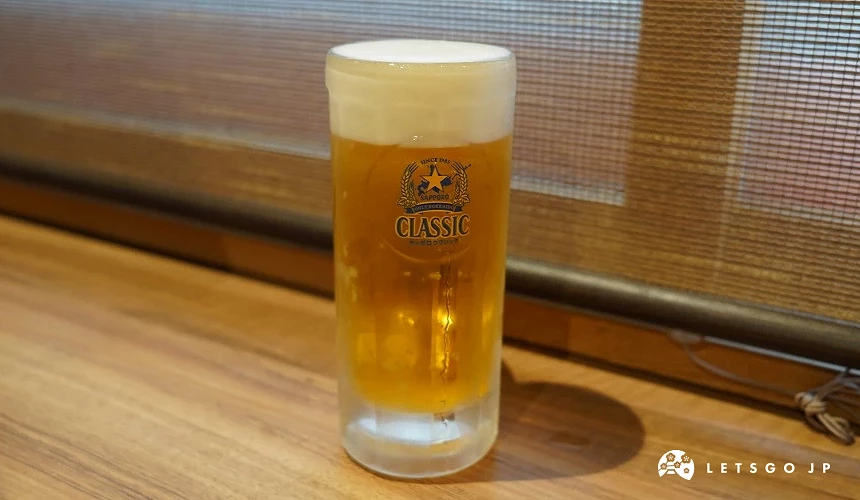 一杯 Sapporo Classic 啤酒置於桌面。
