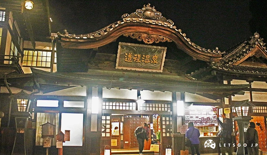 夜晚打燈後的道後溫泉本館,古色古香的木造建築與入口處寫有道後溫泉的復古牌匾