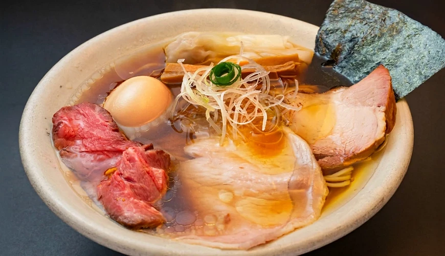 放入叉燒、糖心蛋、海苔、筍乾的醬油湯底拉麵