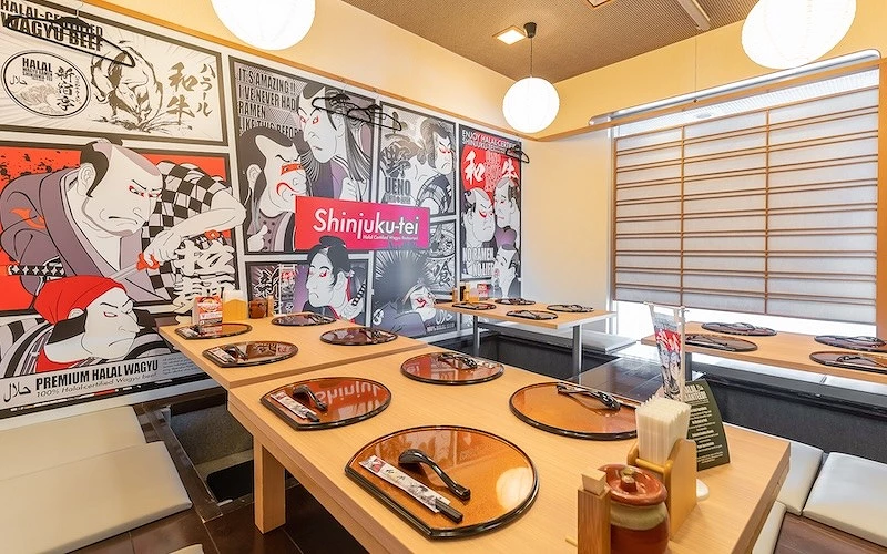 餐廳室內座位區,牆面浮世繪風格插畫與桌上餐具