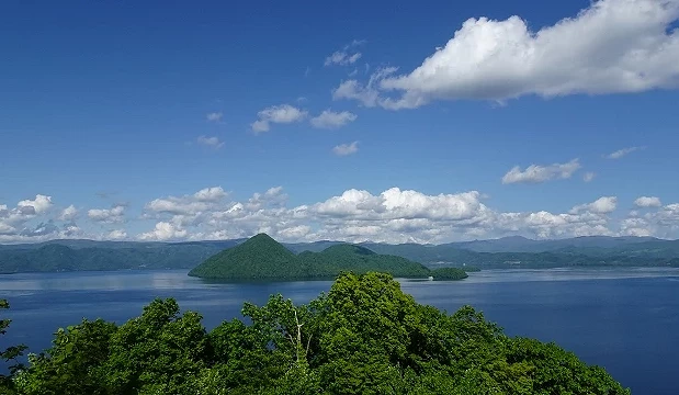 夏季洞爺湖俯瞰景色,藍色湖面清澈,中央可見中島群島,前景為綠色樹林與遠方山巒