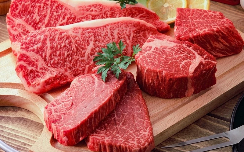 木板上擺放多塊高油花生牛排與厚切牛肉塊