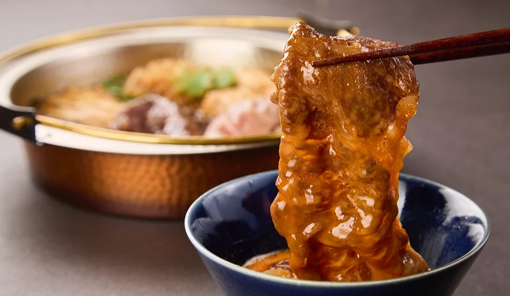 壽喜燒肉片沾上蛋汁的模樣