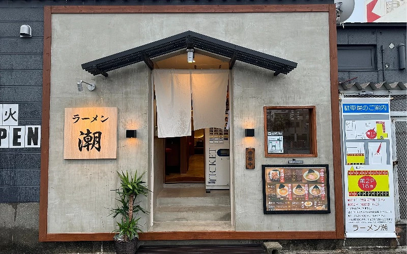 拉麵店外觀,門口掛有暖簾與菜單看板