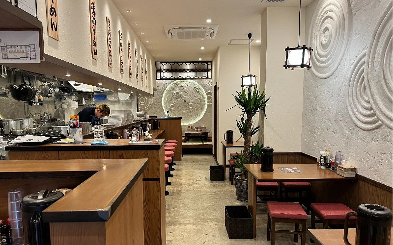 拉麵店室內用餐區,吧台座位與廚房作業區