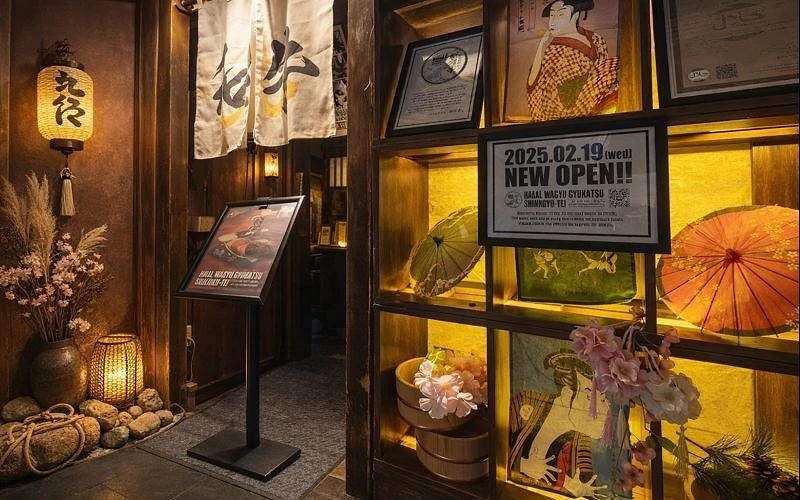 左邊為九宮格展示櫥窗中間是白色暖簾上面寫著和牛兩個字右邊則是站立的日式燈籠