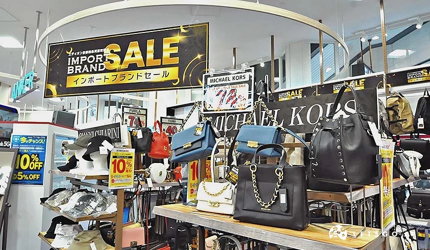 多個名牌包展示在難波愛店王的一樓包包區,附近亦掛上了優惠活動資訊的展板