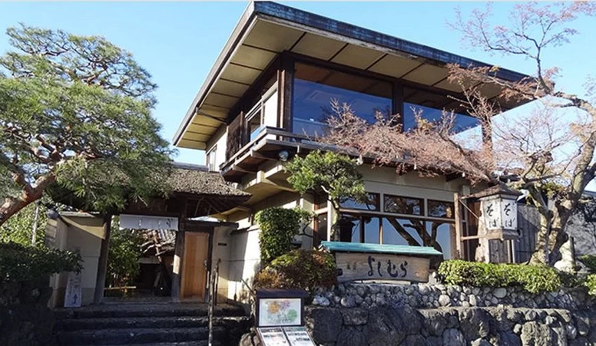 嵐山渡月橋附近的蕎麥麵名店「嵐山よしむら」外觀,為結合木造建築與大片玻璃窗的日式餐廳