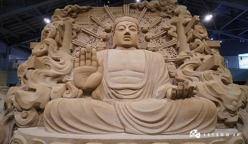 砂之美術館內大型佛像沙雕作品,細緻雕刻呈現莊嚴坐姿與繁複背景裝飾