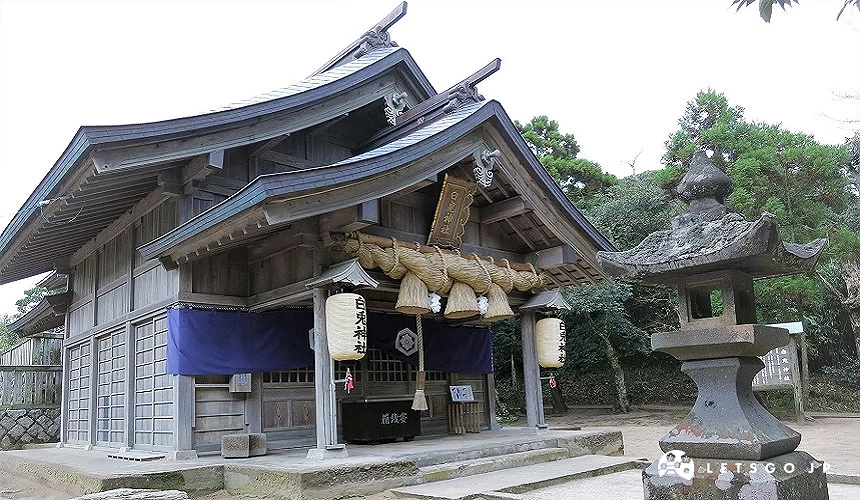 鳥取白兔神社本殿建築外觀,木造神社前懸掛巨大注連繩與燈籠,旁側設有石燈籠與綠樹環繞