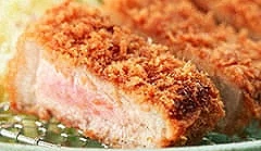 日式炸豬排切面特寫,金黃麵衣包裹多汁豬肉的定食料理
