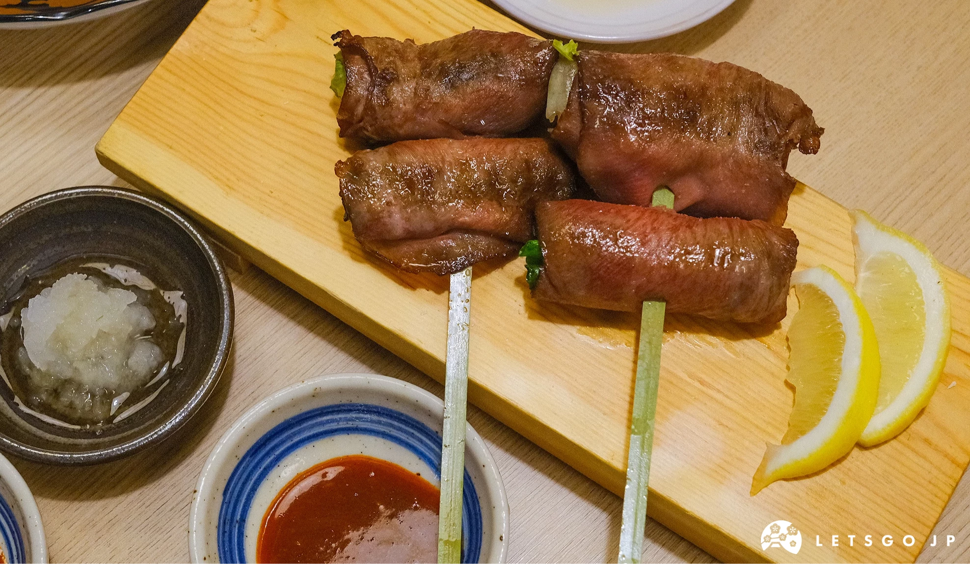 薄切牛舌捲串包有生菜和蔥段