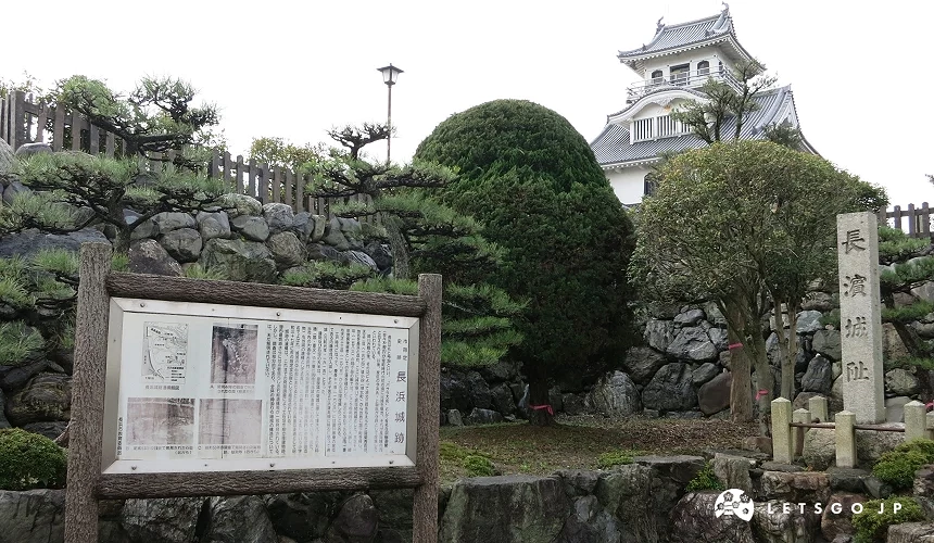 石碑刻有「長濱城址」,後方松樹與石垣間可見城郭天守閣