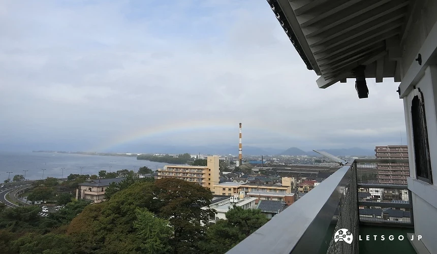 從城閣觀景台眺望湖岸市區,遠方出現彩虹與紅白色工廠煙囪