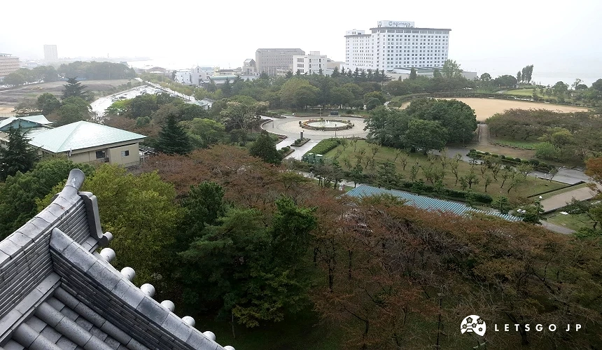 從城閣俯瞰下方公園圓形廣場及樹林,遠處可見湖岸與飯店建築