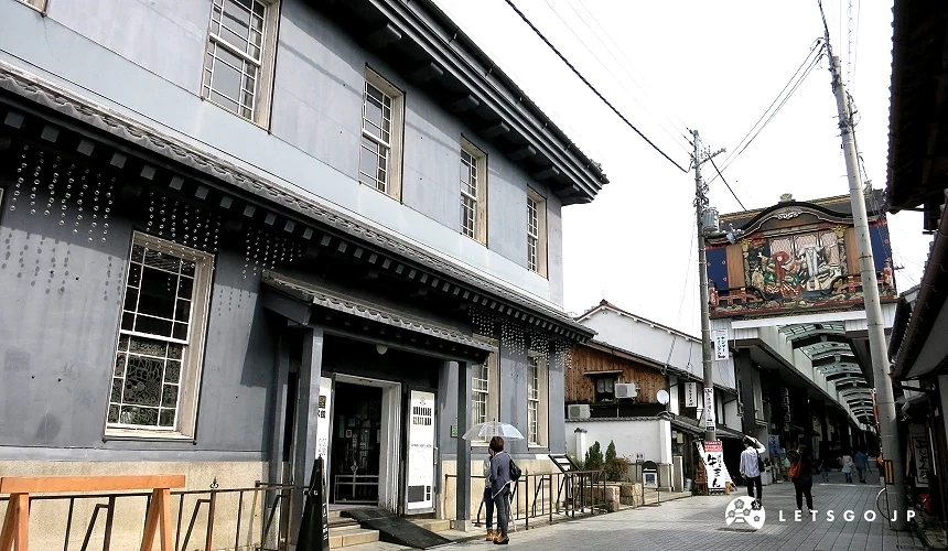 傳統街道,左側為藍灰色老建築,右側遠處可見裝飾華麗的建築立面