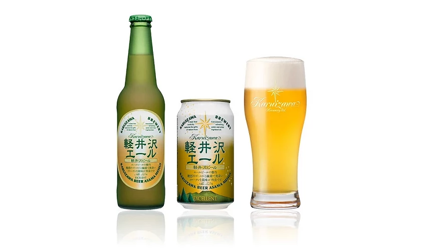 輕井澤艾爾啤酒(軽井沢エール)的商品展示,包含左側的綠色玻璃瓶裝、中間的白底金字易開罐,以及右側倒滿金黃色啤酒與濃密泡沫的專屬玻璃杯