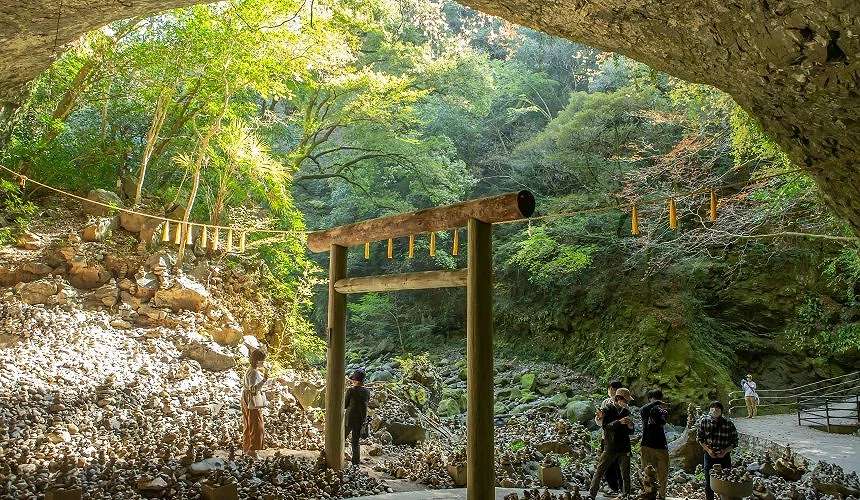 天安河原巨大的岩洞內矗立著鳥居,周圍堆滿了祈願者疊起的無數石塊,散發強大能量