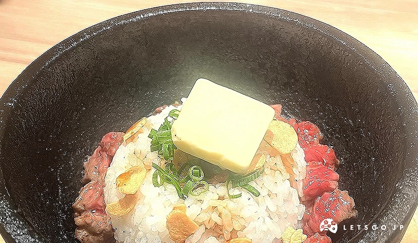 石鍋中盛裝了白飯、肉塊、奶油等配料