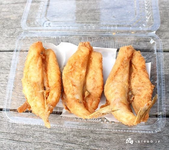 透明盒中擺放多塊炸魚料理,金黃酥脆外觀