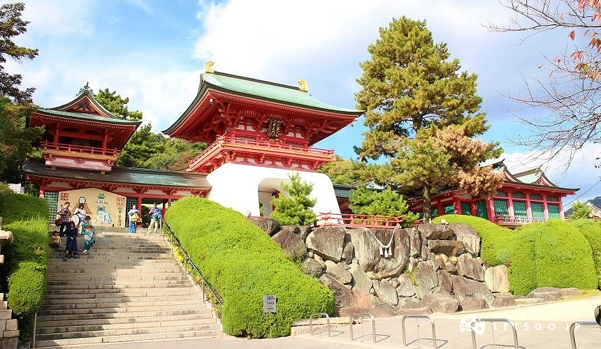 赤間神宮入口階梯與紅色社殿建築,周圍綠樹環繞,遊客參拜
