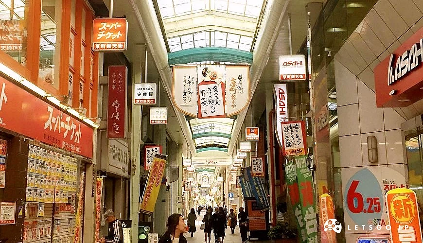 小倉商店街內部景觀,有拱形屋頂與各式招牌,行人穿梭其中