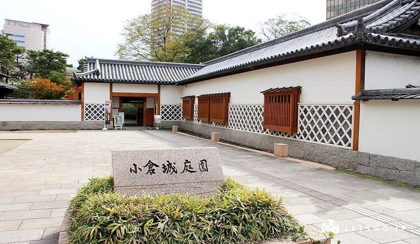 小倉城庭園入口與白牆建築,前方石碑寫有「小倉城庭園」字樣