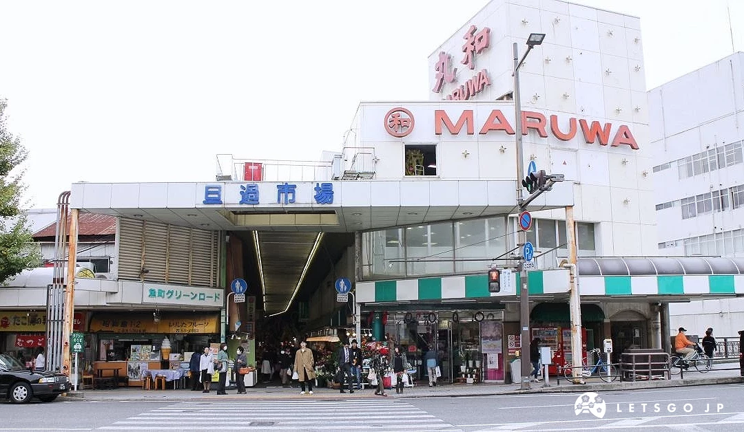 旦過市場入口與街道景觀,上方寫有市場名稱,周邊為商店與行人