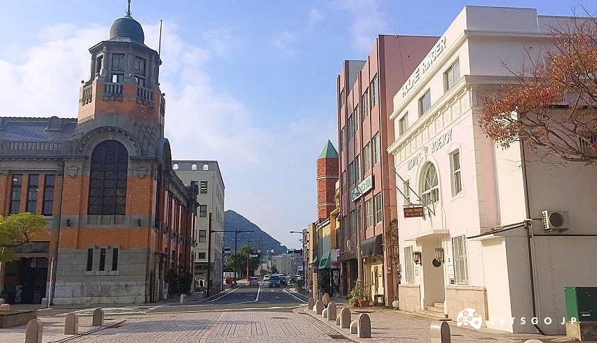 門司港懷舊區街道景觀,左側為紅磚歷史建築,右側歐風建築林立,遠方可見山景