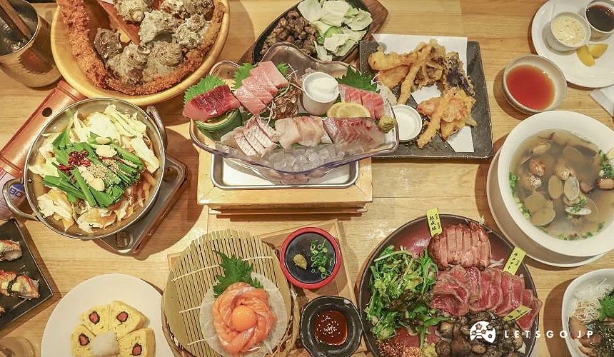 桌上有生魚片、牛腸鍋等各式福岡美食