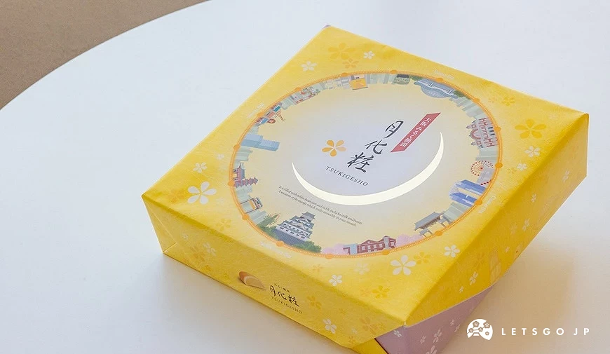 黃色方形包裝盒,印有月化粧字樣與城市景點插畫