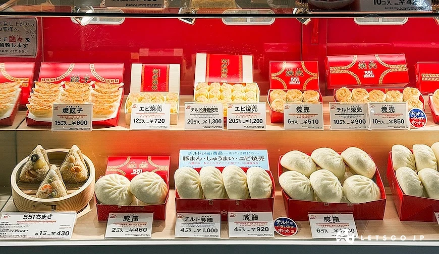 551 HORAI 玻璃展示櫃,內部陳列煎餃、燒賣、肉包與粽子等商品模型及標價