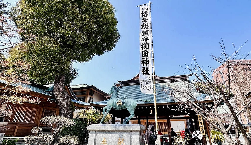 神社手水舍旁豎立著博多總鎮守櫛田神社的幡旗與馬匹石像
