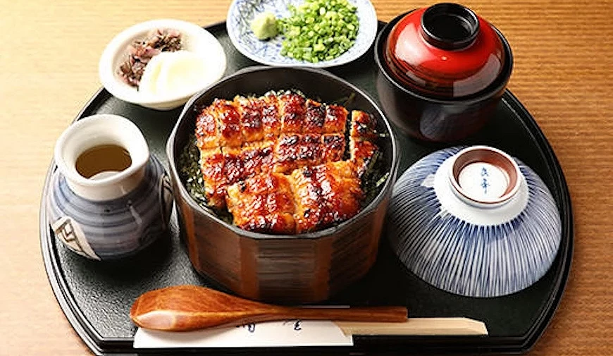 鰻魚飯套餐盛裝於木製圓盒,附湯碗、薬味碟與茶杯,擺放於黑色托盤上