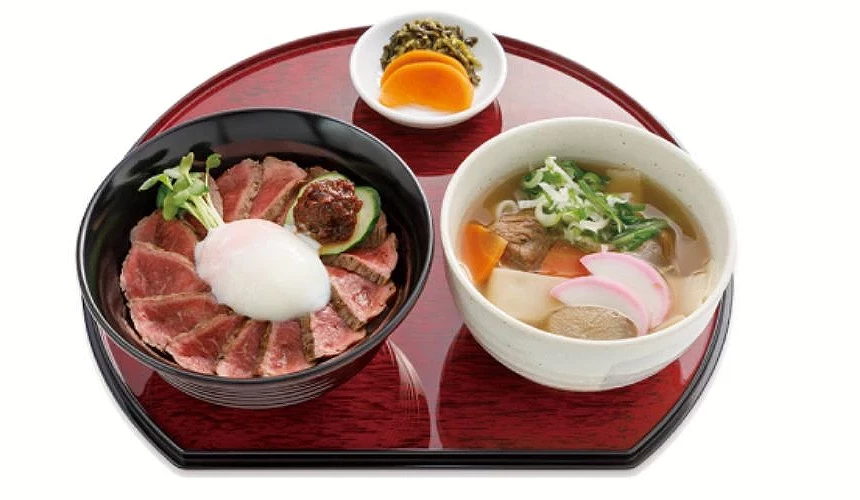 阿蘇赤牛丼套餐,丼飯上鋪有赤牛肉片、溫泉蛋與味噌醬,旁邊搭配鄉土湯和漬物