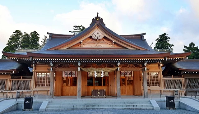 熊本縣阿蘇神社拜殿正面,木造建築屋頂下方懸掛注連繩,前方設有參拜步道