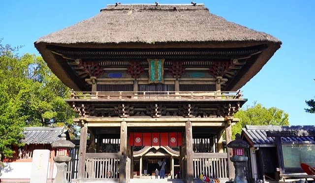 熊本縣人吉市青井阿蘇神社的茅草屋頂樓門,木造門樓前方設有石燈籠與參拜入口