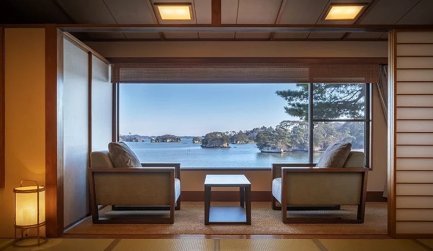 小松館好風亭日式客房內設有兩張窗邊座椅,大片窗外可見松島灣與多座小島景色