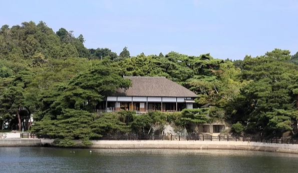 松島灣畔的觀瀾亭被松樹林環繞,傳統建築面向海面,前方可見平靜水岸
