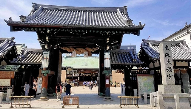 大阪天滿宮入口正門與鳥居,石碑標示神社名稱,遊客從門口進入境內參拜