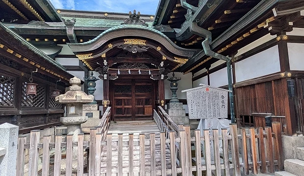 大阪天滿宮登龍門建築,木造結構與曲線屋頂,前方設有參拜階梯與圍欄