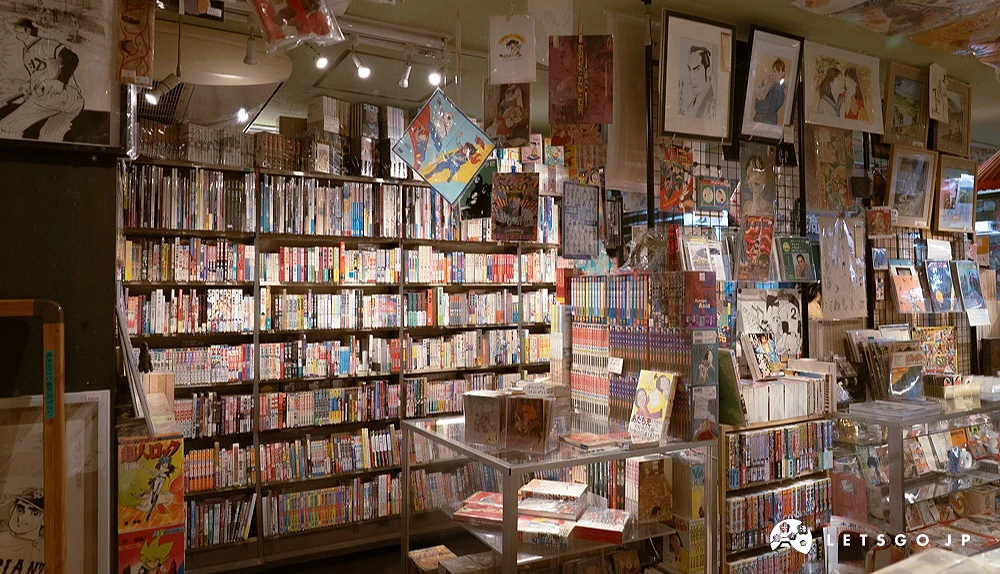 以密密麻麻擺滿舊書與漫畫期刊的木質書架為背景的「夢野書店」,櫃檯旁整齊堆疊的早期珍貴出版物,呈現該店鋪特有的懷舊動漫藏書陳列景觀。