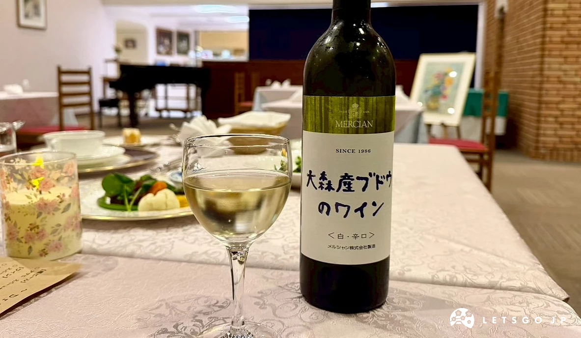 西式餐桌上擺放著一瓶大潟村產紅酒與一杯白葡萄酒。