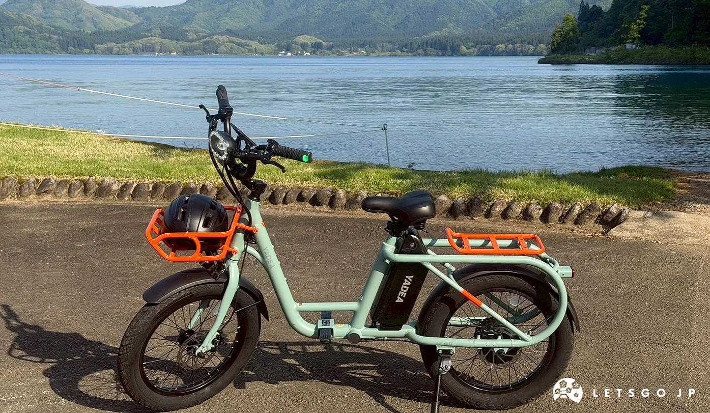 停放在田澤湖畔草地旁的薄綠色微型電動二輪車。