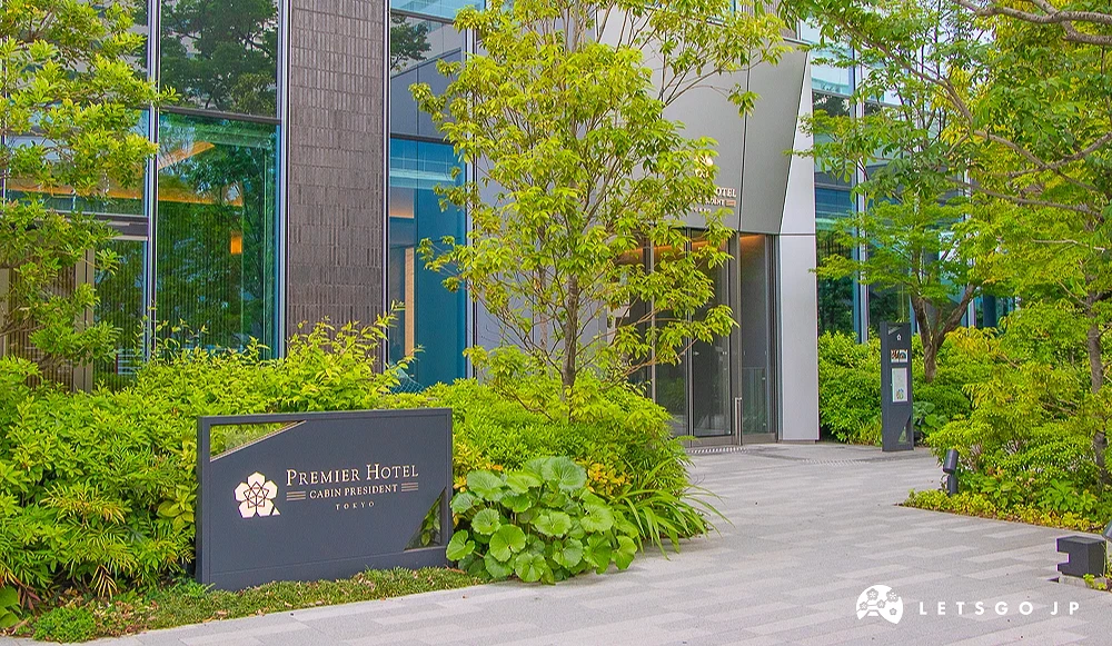 普雷米爾飯店晴海入口 飯店步道旁立有「PREMIER HOTEL CABIN PRESIDENT TOKYO」石牌,後方為玻璃大門。