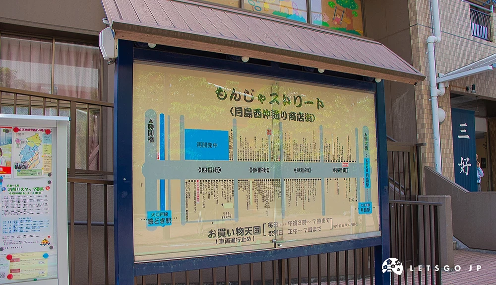 月島文字燒街導覽地圖 深藍色支架的佈告欄內,展示著月島西仲通商店街的文字燒店家位置地圖。